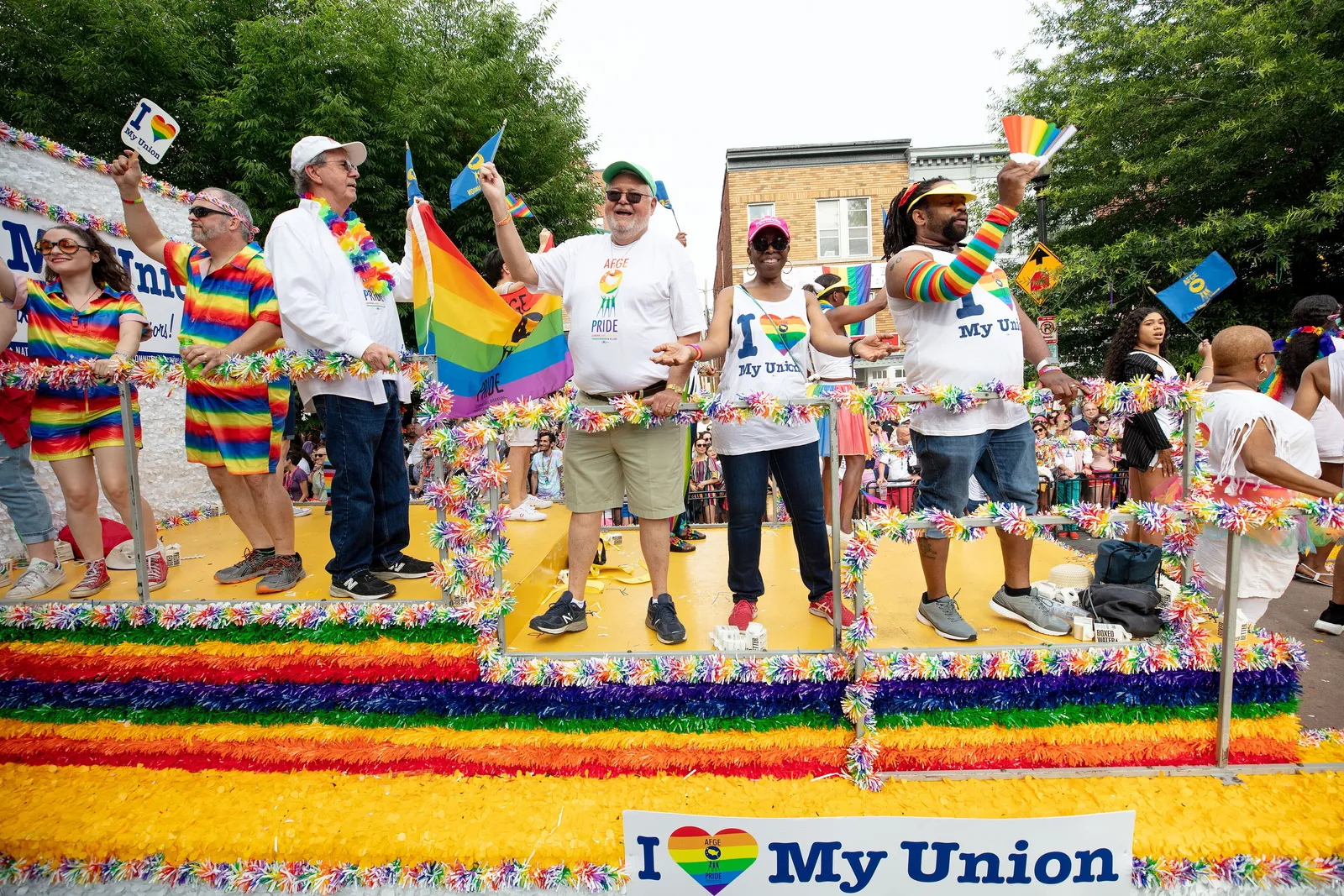 A rainbow-decked float and marchers waving Pride flags along a street during the Capital Pride Parade in Washington, D.C.