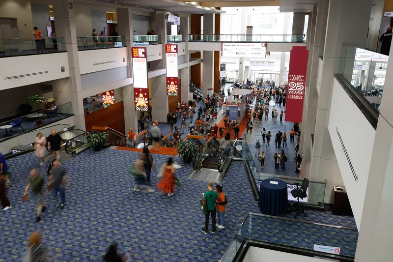 Crowds filling the hall of the Walter E. Washington Convention Center under festival banners during the Library of Congress National Book Festival in Washington, D.C.